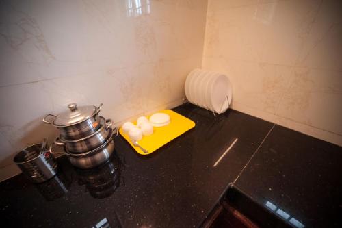 a kitchen counter with a pot and some food at Shanthi Service Apartment in Madurai