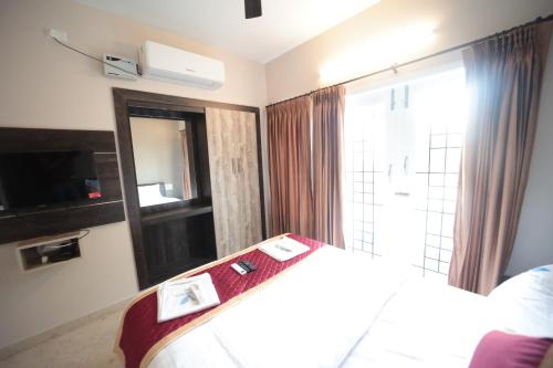 a hotel room with a bed and a large window at Shanthi Service Apartment in Madurai