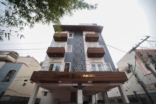a tall building with a sign in front of it at Shanthi Service Apartment in Madurai