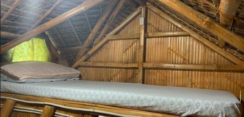a bed in a room in a wooden cabin at PAPABO Adventure Village in Moalboal