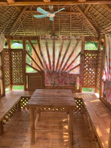 a wooden table in a pavilion with a ceiling fan at PAPABO Adventure Village in Moalboal