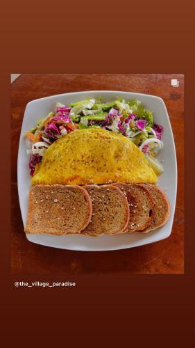 un plato de comida con un sándwich y una ensalada en Village Paradise, en Beliatta