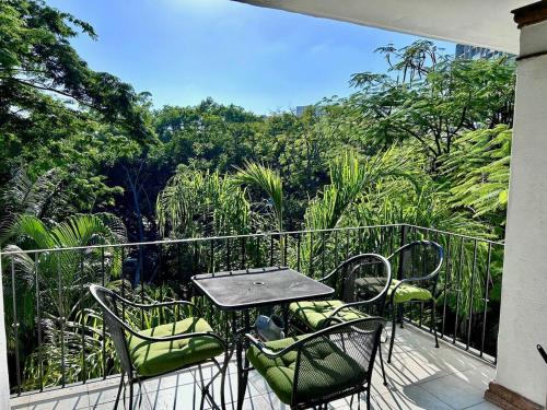 a patio with a table and chairs on a balcony at 2 Bedroom Treetop Condo in Puerto Vallarta