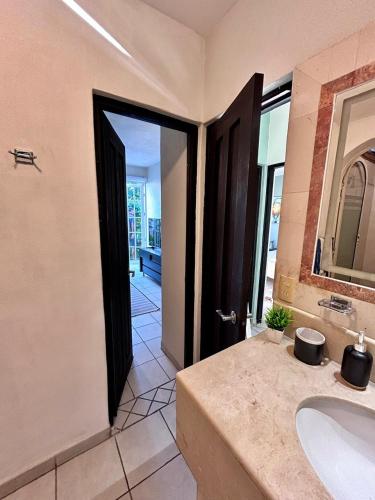 a bathroom with a sink and a black door at 2 Bedroom Treetop Condo in Puerto Vallarta