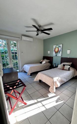 a bedroom with two beds and a ceiling fan at 2 Bedroom Treetop Condo in Puerto Vallarta