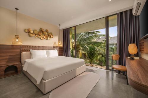 a bedroom with a white bed and a balcony at Peaceful 2BDR Hoi An APT near An Bang beach and Ancient Town in An Bang