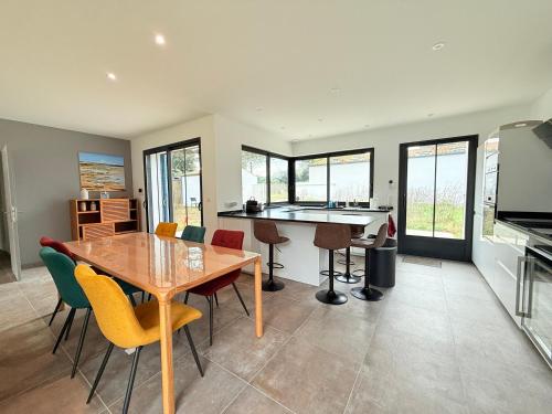 une cuisine et une salle à manger avec une table et des chaises en bois dans l'établissement Maison neuve 3 chambres, proche plage, grand jardin - FR-1-778-37, à Saint-Pierre-dʼOléron