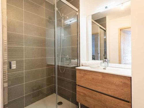 ein Badezimmer mit Dusche, Waschbecken und Spiegel in der Unterkunft Neuf T2 avec balcon, parking et casier à skis, idéal pour 4 personnes - FR-1-291-1021 in Valmorel