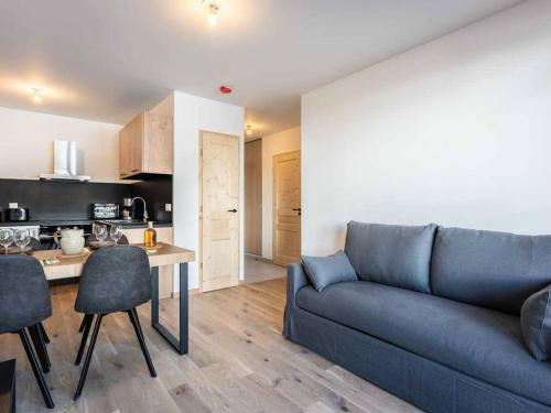 un salon avec un canapé bleu et une cuisine dans l'établissement Neuf T2 avec balcon, parking et casier à skis, idéal pour 4 personnes - FR-1-291-1021, à Valmorel