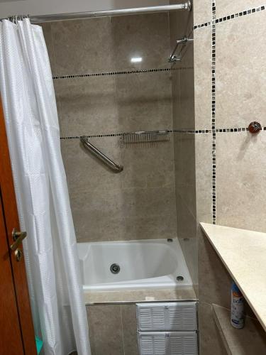 a bathroom with a tub and a shower with a shower curtain at Complejo Médanos in San Bernardo