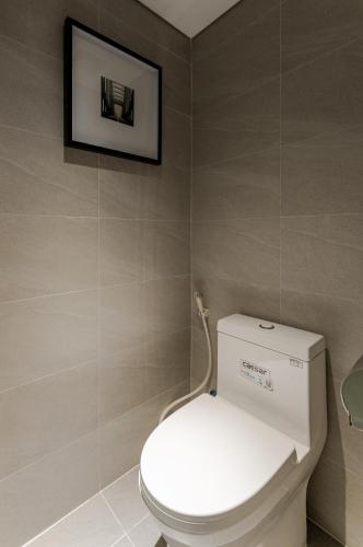 a bathroom with a toilet with a picture on the wall at The Zénith, By Harrys in Hanoi