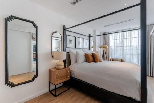 a bedroom with a large bed and a mirror at The Zénith, By Harrys in Hanoi