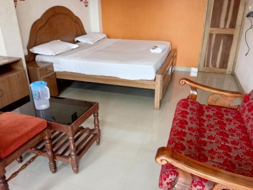 a room with a bed and a chair and a table at Mattuppavu Beach House in Vilinjam