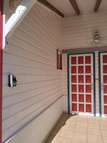 a garage with a red door on a wall at Villa-BlueHorizon180 in Ducos