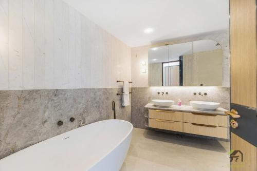 a bathroom with two sinks and a tub and a mirror at Harbour view new year firework in Sydney