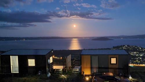 a view of a house with the moon in the sky at Aorangi Peak Cabins 7 by Tiny Away in Rotorua