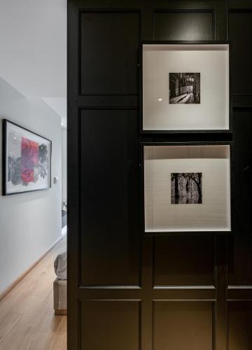 a black wall with two framed photographs in a room at The Zénith, By Harrys in Hanoi