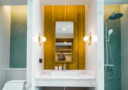a bathroom with a white sink and a mirror at Phi Phi at Pier in Phi Phi Don