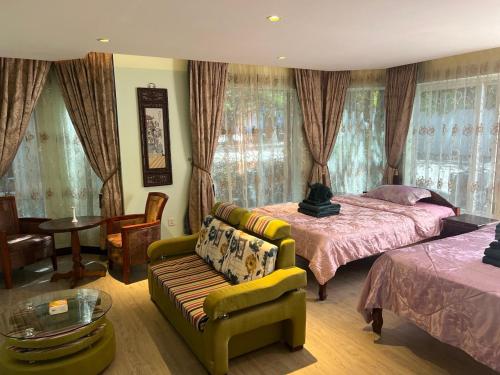 a bedroom with a bed and a couch and a table at Hawaii Lounge in Sihanoukville
