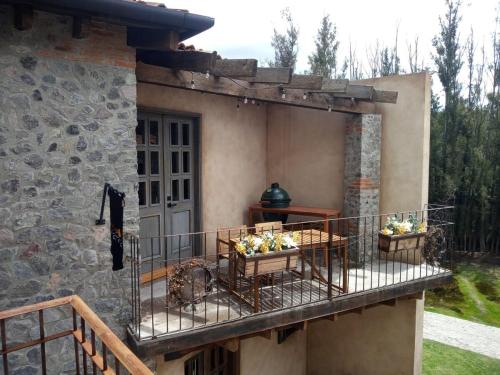 a house with a balcony with flowers on it at Penthouse Santorino en Valquirico in Santeagueda