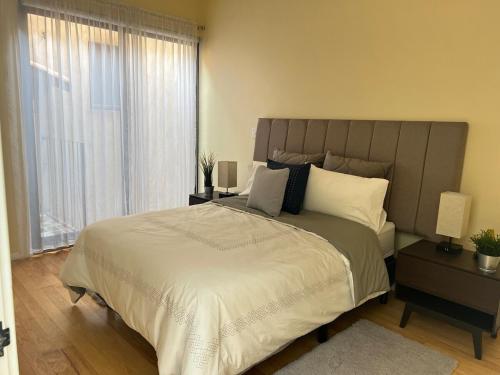 a bedroom with a large bed and a large window at Penthouse Santorino en Valquirico in Santeagueda