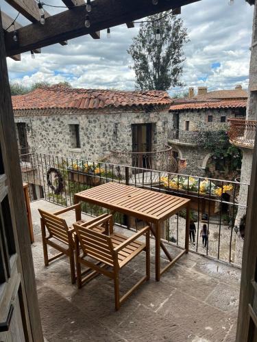 a wooden table and two chairs on a balcony at Penthouse Santorino en Valquirico in Santeagueda