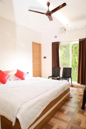 une chambre avec un grand lit avec un ventilateur de plafond dans l'établissement Coconad Resort, à Alappuzha