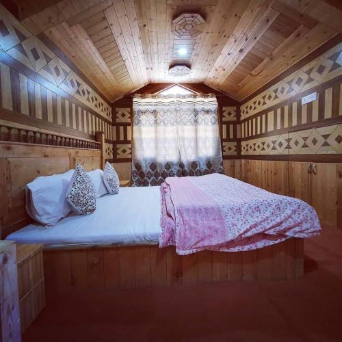 a bedroom with a bed in a wooden room at Ashirwad Homestay near Kufri in Theog