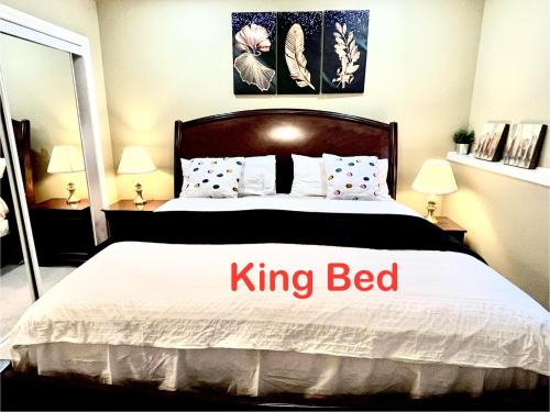 a bedroom with a king bed with the words king bed at Cozy Walkout suite with King bed, Kitchen, Parking & Patio in Calgary