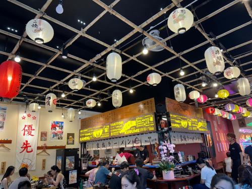 a restaurant with people sitting at tables and lights at Luxury apartment with River view Landmark2 Ecopark in Kim Quan