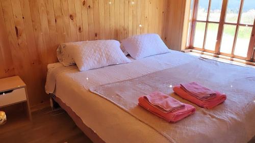 a bedroom with a bed with two bags on it at Cabañas Alelí in Chaitén