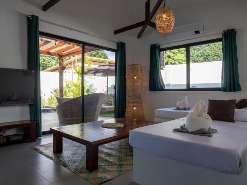 a living room with a couch and a table at Paraluman, large Villa with pool in El Nido