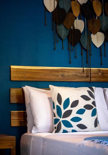 a bedroom with a blue wall and a bed with a pillow at Paraluman, large Villa with pool in El Nido