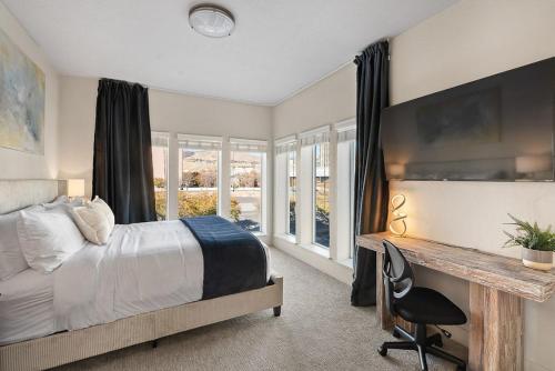 a bedroom with a bed and a desk and windows at Gorgeous 2BD 2BA Pool,Gym,Htub near Convention Ctr in Salt Lake City