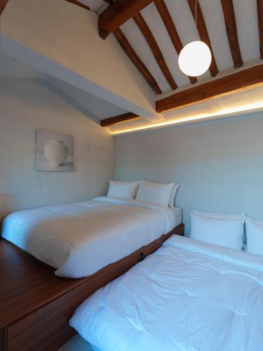two beds sitting next to each other in a room at Bukchon Hanok - 'Yul Jae' The access code is sent by message in Seoul