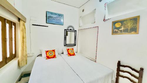 a white room with two beds in it at Hotel White House - A Family Homestay in Pushkar