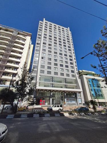 a large white building with a car parked in front of it at Exquisite Sanctuary Of Luxury Bole in Addis Ababa