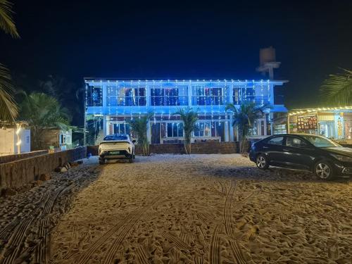 a blue building with cars parked in front of it at Gokarna Govekar Sea Facing Rooms in Gokarn