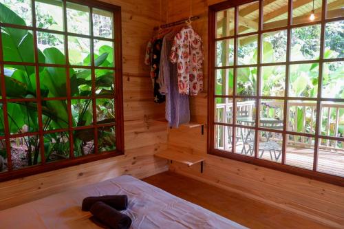 a bedroom with windows and a bed in a room at Rainbow Lodge Costa Rica in Savegre