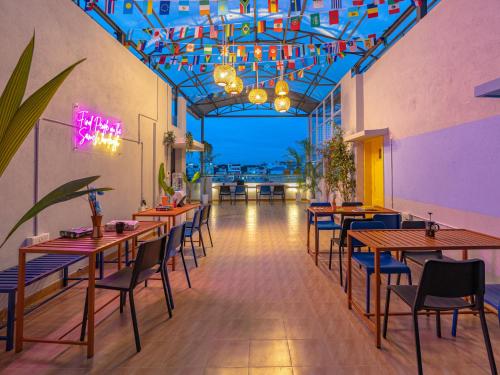 班加罗尔The Hosteller Bangalore, Koramangala的有木桌椅和灯光的餐厅