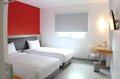 a hotel room with two beds and a table at Amaris Hotel Setiabudhi - Bandung in Bandung