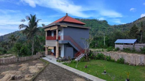 een huis met een rood dak en een hek bij Tirta Unda Sidemen in Sidemen