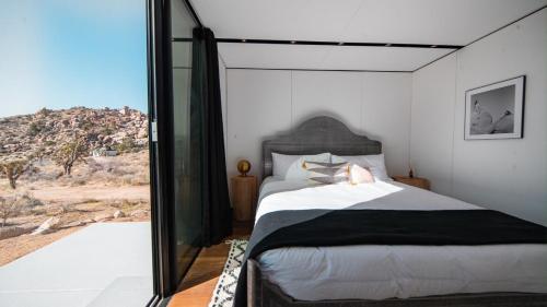 a bedroom with a bed with a view of the desert at Sol to Soul - Distinguished as the Coolest In Cali in Pioneertown