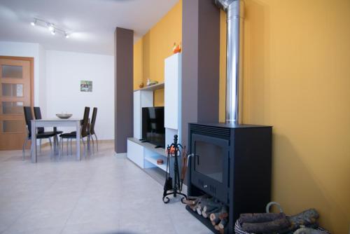 a living room with a fireplace and a dining room at Apartament Bagà in Bagá