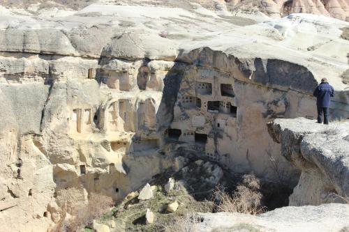 a man standing on the side of a mountain at Fairyland Cave Hotel in Goreme