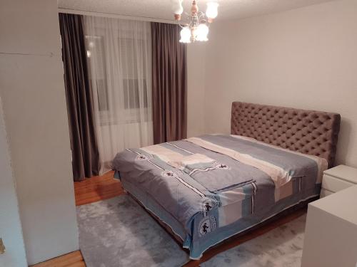 a bedroom with a bed in a room with a chandelier at Apartman Milosavljević in Železnička Stanica Ćele Kula