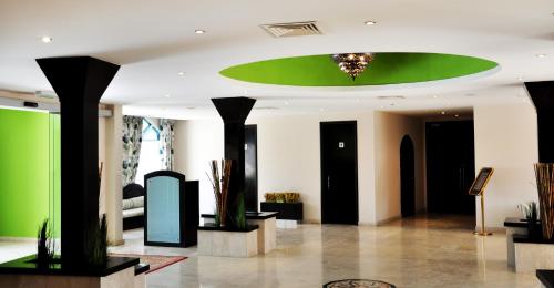 a lobby with a green and black ceiling at Al Wadi Hotel in Sohar