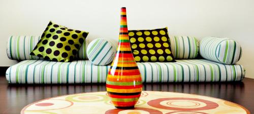 a colorful vase sitting on a table in front of a couch at Al Wadi Hotel in Sohar
