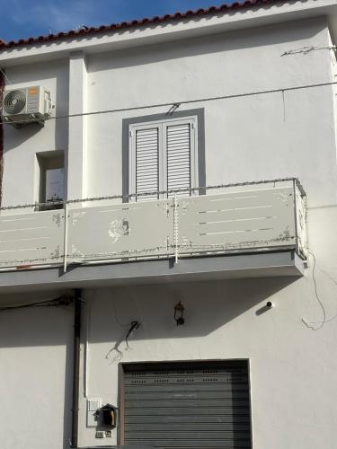 a white building with a balcony and a window at Ruggiero house Pompei in Pompei