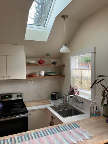 a kitchen with a sink and a stove and a window at Cozy Alley Cottage, Concordia, Alberta Arts, NE PDX in Portland